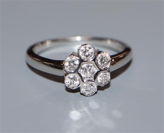 A modern 18k white gold and seven stone diamond cluster ring, size N.